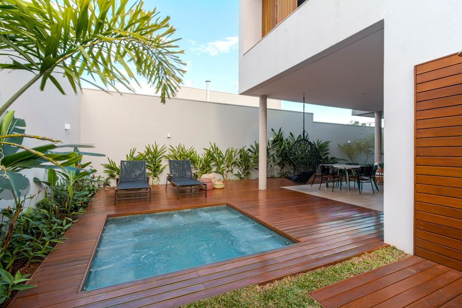 Mini-piscine entourée d'une terrasse en bois dans le patio d'une maison